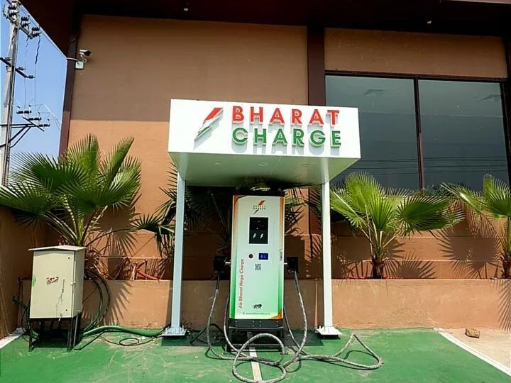 Bharat Charge branded canopy and DC charger on a green-painted bay outside a restaurant