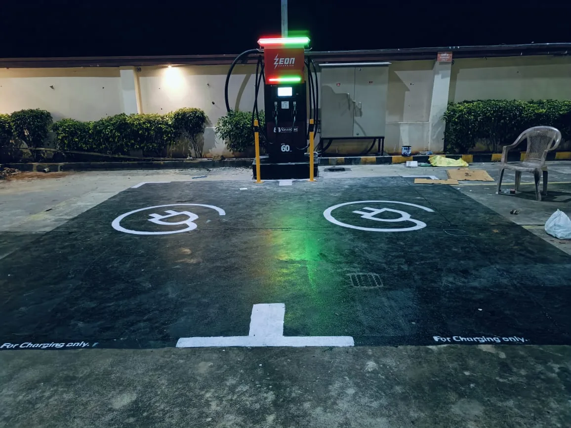 Commissioned 60 kW DC charger with red and green LED status lighting over painted bays